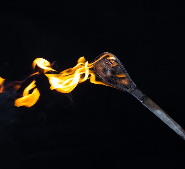 wooden burning torch on a black background