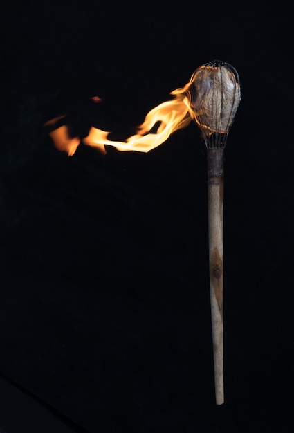 Foto torcia ardente in legno su sfondo nero