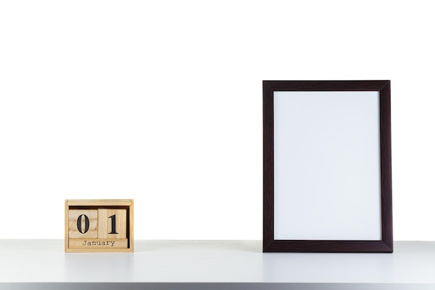 Wooden calendar 01 January with frame for photo on white table and background