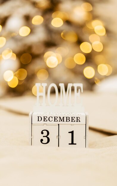 Foto calendario in legno di blocchi con la data del 31 dicembre sullo sfondo sfocato di natale e capodanno. bellissimo bokeh a luce calda. stato d'animo di capodanno. foto