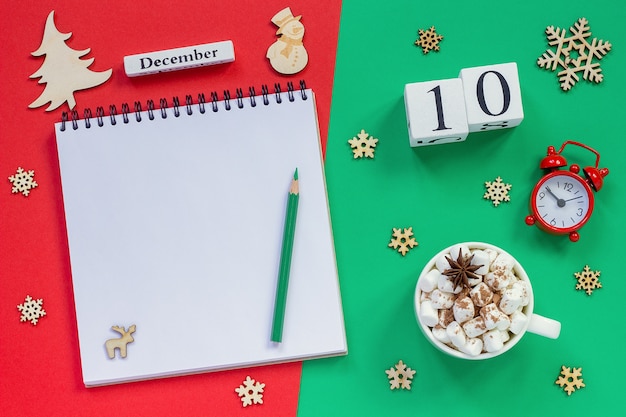 Photo wooden calendar, cup of cocoa with marshmallow and decorations