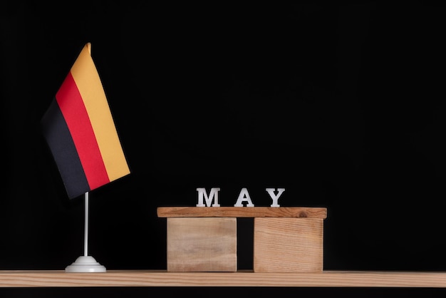 Wooden calendar of May with German flag on black background Dates in Germany in May