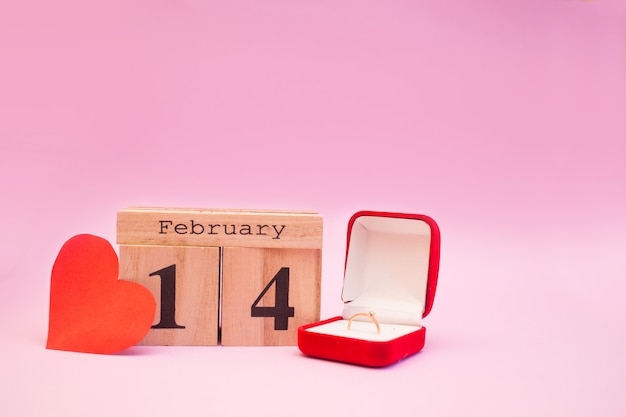 赤いハートとピンクの背景に木製のカレンダー。バレンタインデー2月14日
