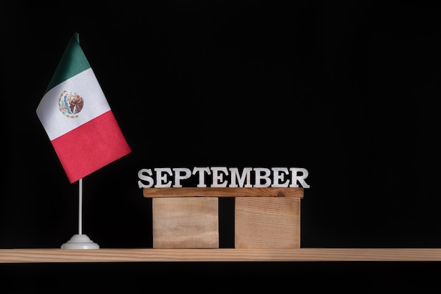 Wooden calendar of September with Mexico flag on black background. Holidays of Mexico in September.