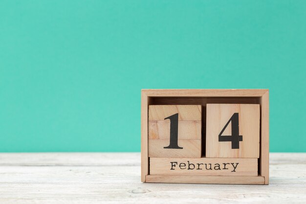 Wooden calendar show of February 14 on wooden tabletop