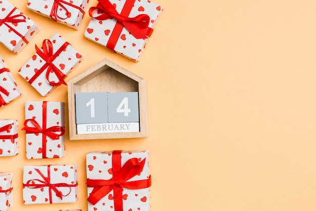 wooden calendar surrounded by wrapped gift boxes with ribbons and textile hearts