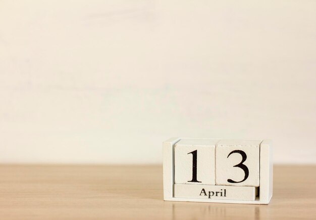 데스크탑에 4월 13일이라는 날짜가 있는 나무 달력.