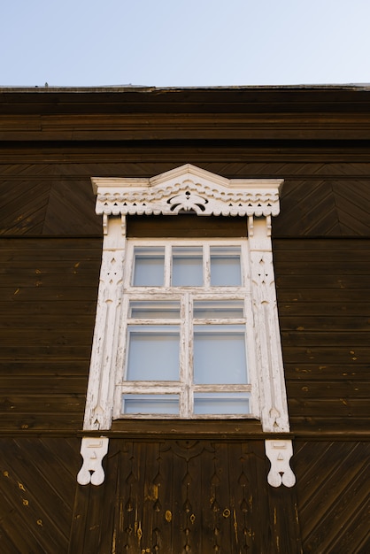 Wooden carved window frame in a wooden russian house