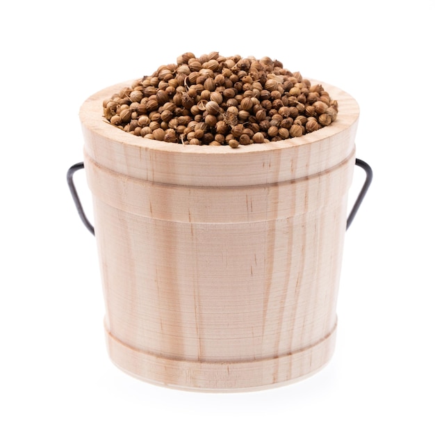 Wooden cask of coriander seeds isolated on white background