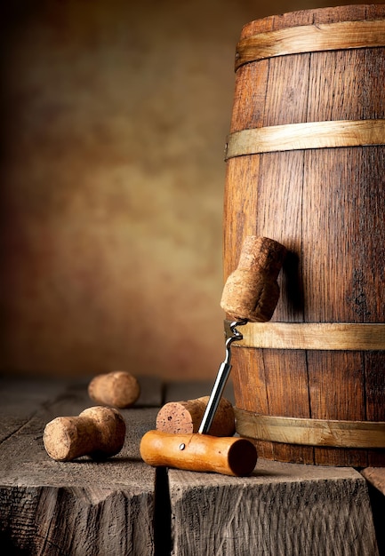 Wooden cask with corks and corkscrew on a table