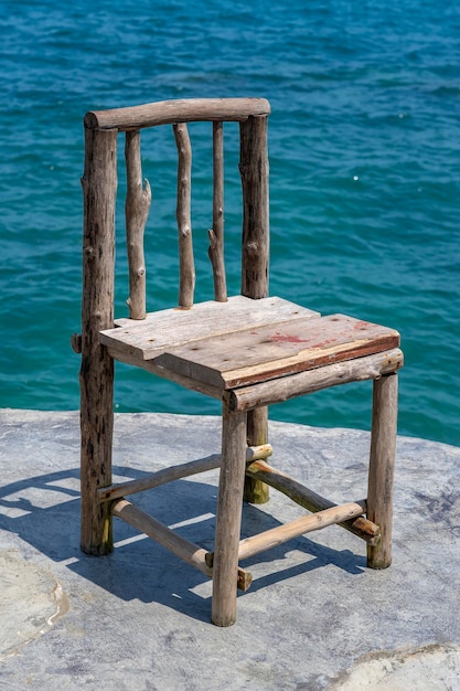 Wooden chair in empty cafe next to sea water in tropical beach Close up Island Koh Phangan Thailand
