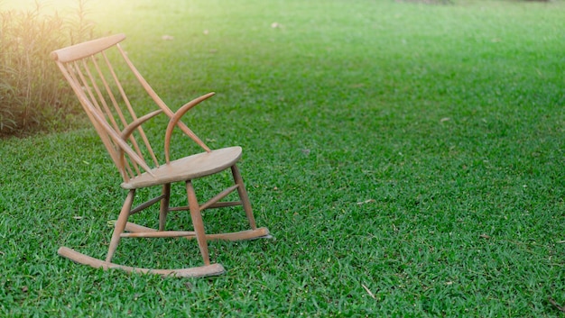 Wooden chair on green grass at garden