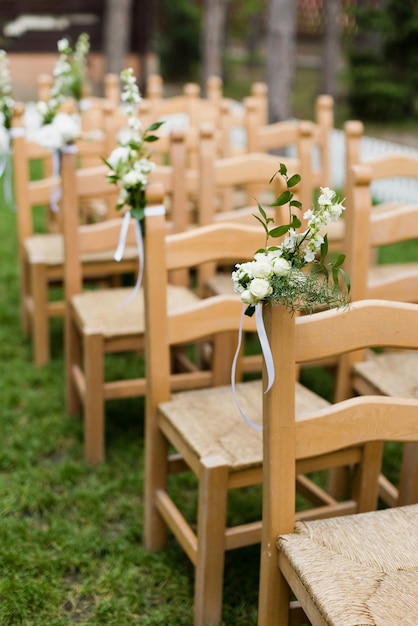 Wooden chairs with flowers wedding ceremony