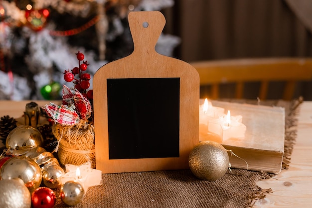 Una lavagna di legno con un albero di natale sullo sfondo