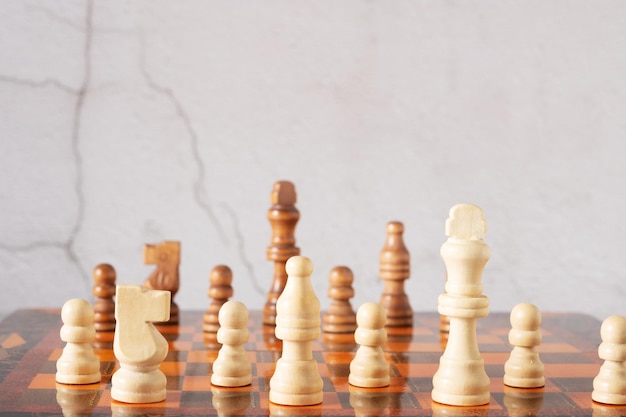 Деревянные шахматы на доске крупным планом на сером фоне