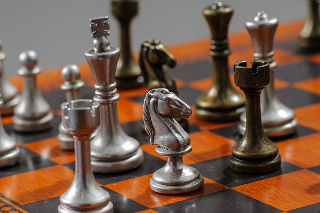 Wooden chess board with metal pieces. Checkmate