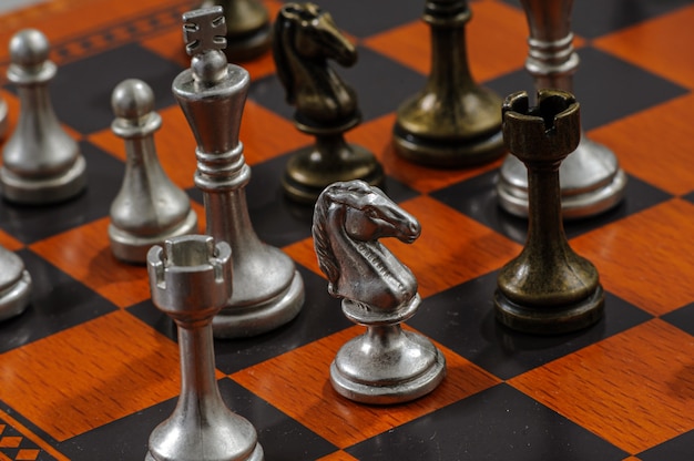 Wooden chess board with metal pieces. Checkmate