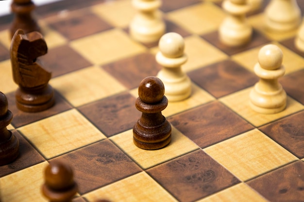 Wooden chess pieces are arranged on a wooden board business\
strategy concept