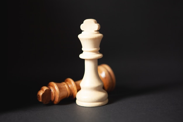 wooden chess pieces on black background