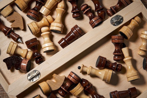 I pezzi degli scacchi in legno si trovano in una scatola aperta per gli scacchi, la strategia, la pianificazione e il processo decisionale.