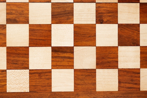 wooden chessboard with figures in light and dark brown tones isolate on a white background