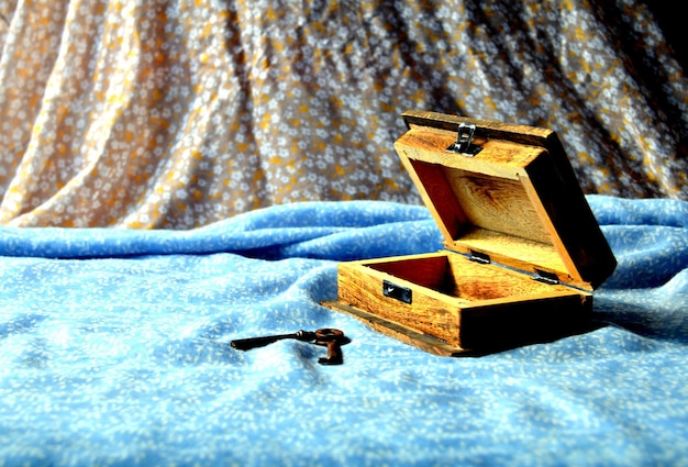 Wooden chest on blue background and old keys next to it.