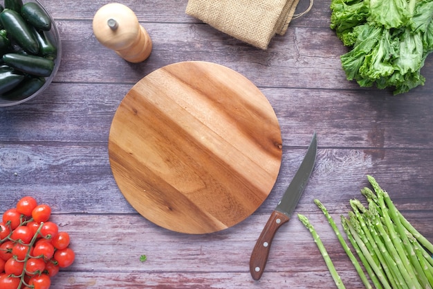 Wooden chopping board with fresh vegetable on table top down