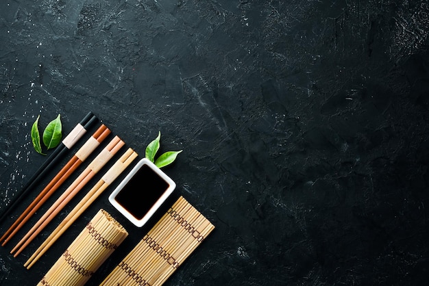 Wooden chopsticks on a black stone background Top view Free space for your text