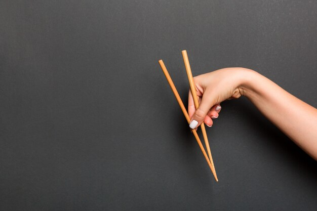 Wooden chopsticks holded with female hand