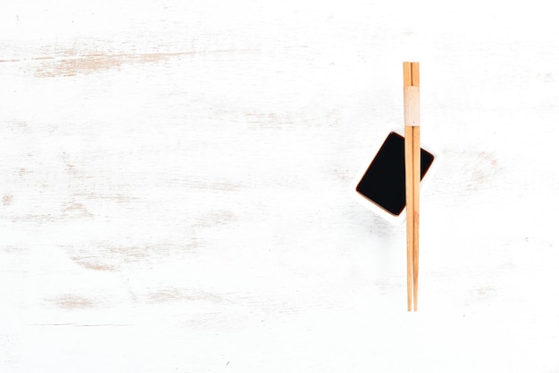 Wooden chopsticks and soy sauce. A set of sticks for Asian cuisine. Top view. Free space for your text.