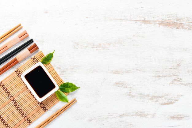 Wooden chopsticks and soy sauce. A set of sticks for Asian cuisine. Top view. Free space for your text.