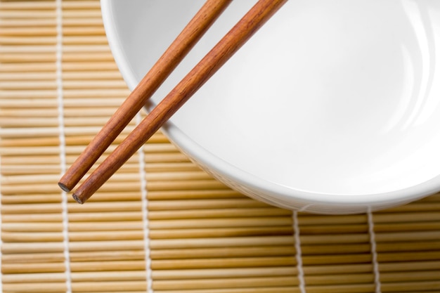 wooden chopsticks on a white bowl isolated on white background