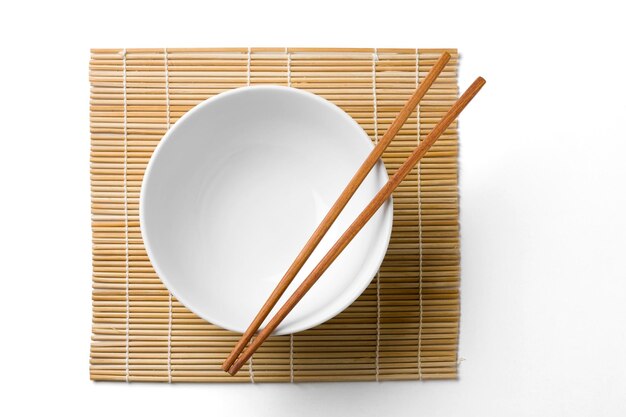 Photo wooden chopsticks on a white bowl