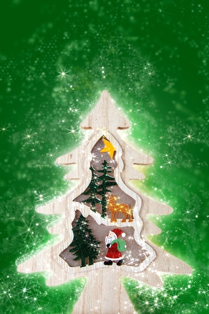 Photo wooden christmas tree with lights on green background.