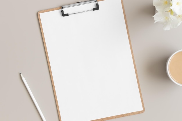 Wooden clipboard mockup with a cup of coffee and oleander on a beige table