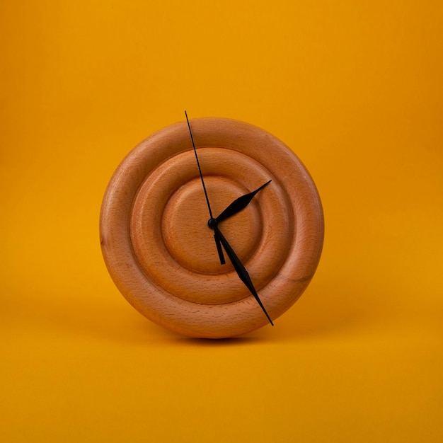 wooden clock on yellow background