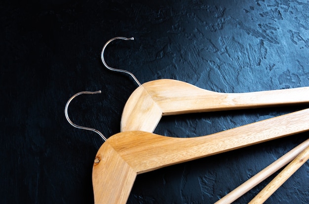 Wooden clothes hanger on black background.