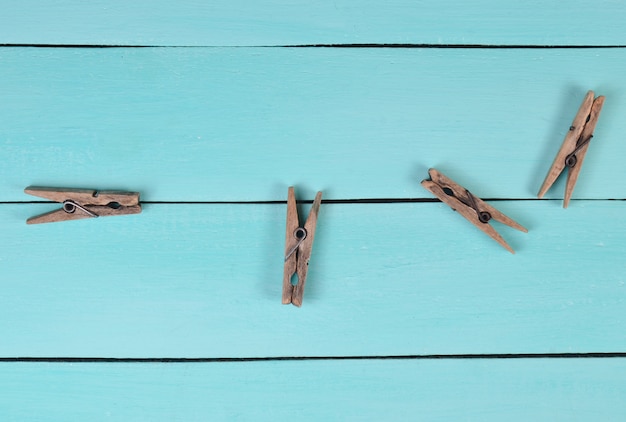 Wooden clothespins on a blue table, top view