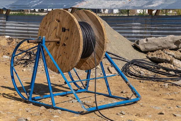 写真 電線の屋外の木製コイル 貯蔵コイルの高電圧および低電圧ケーブル 産業用ワイヤー