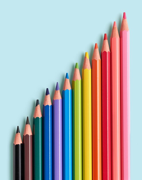 Wooden color pencils isolated on blue background, top view