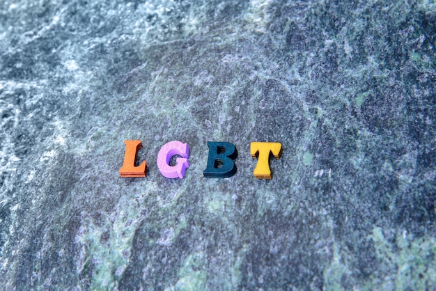 wooden colored letters LGBT on a blue marble background