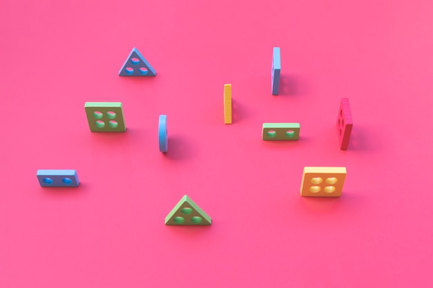 Photo wooden colorful geometric shapes on pink table