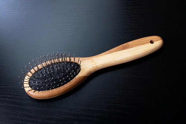 Wooden comb on a black background closeup