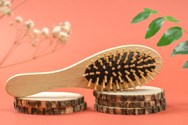 Wooden comb on a wooden podium Hair care with natural accessories Zero waste no plastic