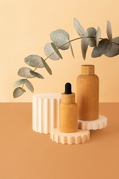 Wooden cosmetics containers on the pastel isometric background.Geometrical podium and fresh eucalyptus branch behind.Earth colors,zero waste containers.Mockup concept.