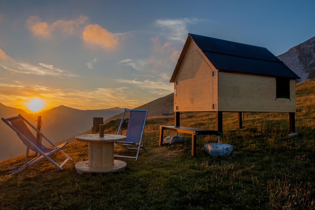 Wooden cottage in the mountains at sunset