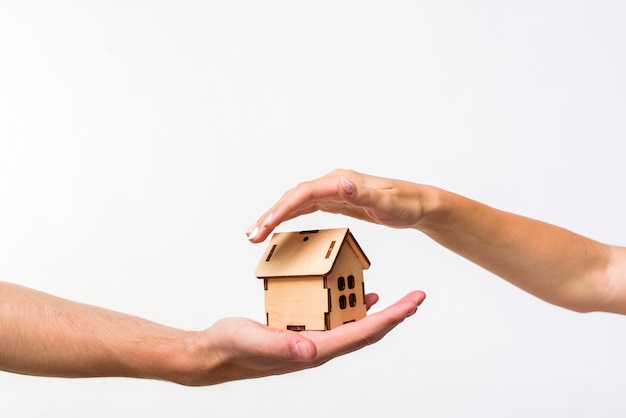 Photo wooden cottage protected by hands