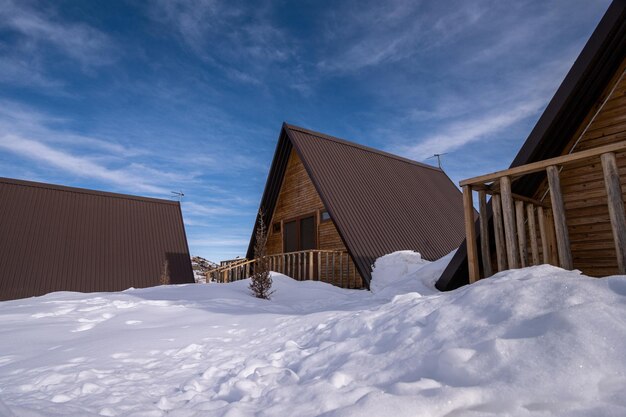 The wooden cottages surrounded by snow A recreation area in the mountains