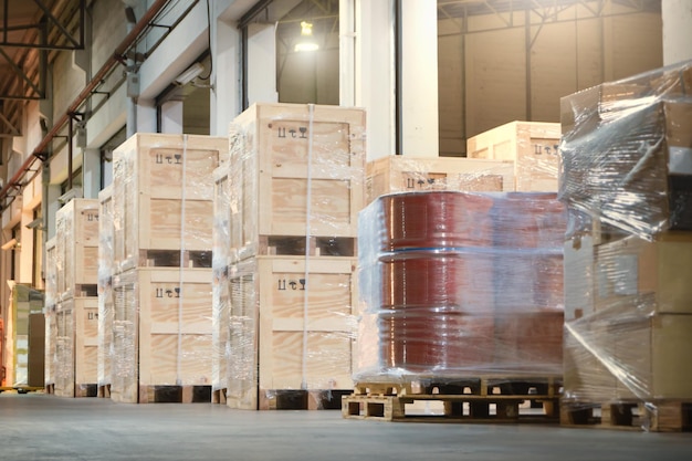 Фото Деревянные ящики и бочковые резервуары из пластика, упакованные на поддоны в складских цепях поставок