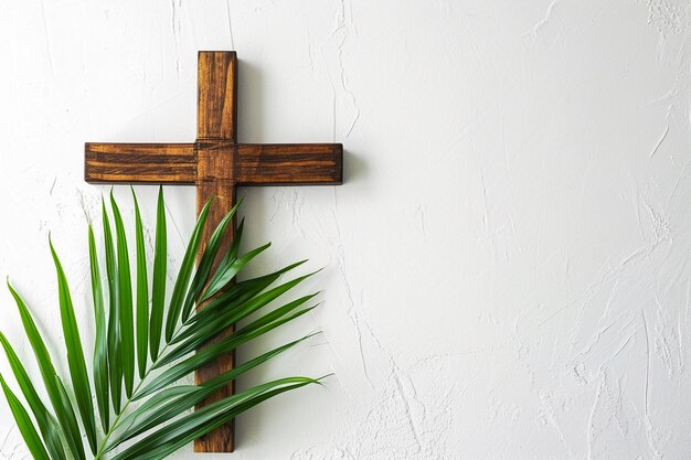 wooden cross adorned with green palm leaves against a white background